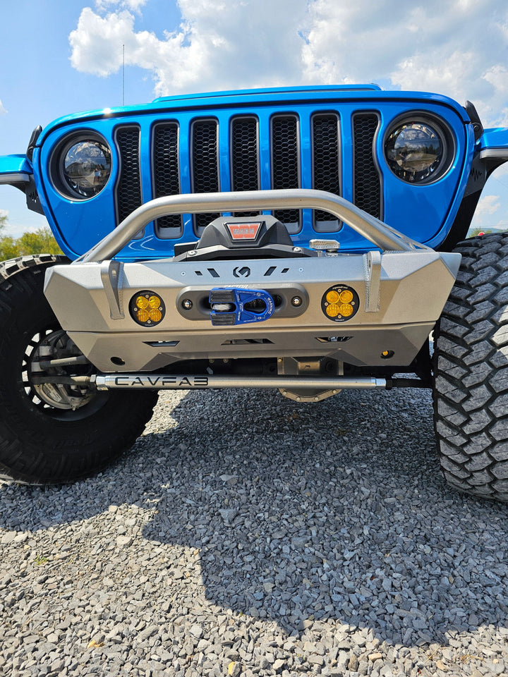 Blue Jeep front with off-road bumper and large tires.