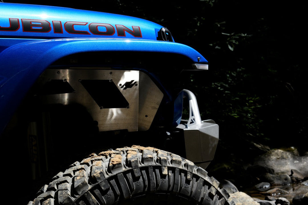 2026 Jeep Wrangler vs 2025 comparison showing updated fender design and off-road tire setup on rugged terrain.