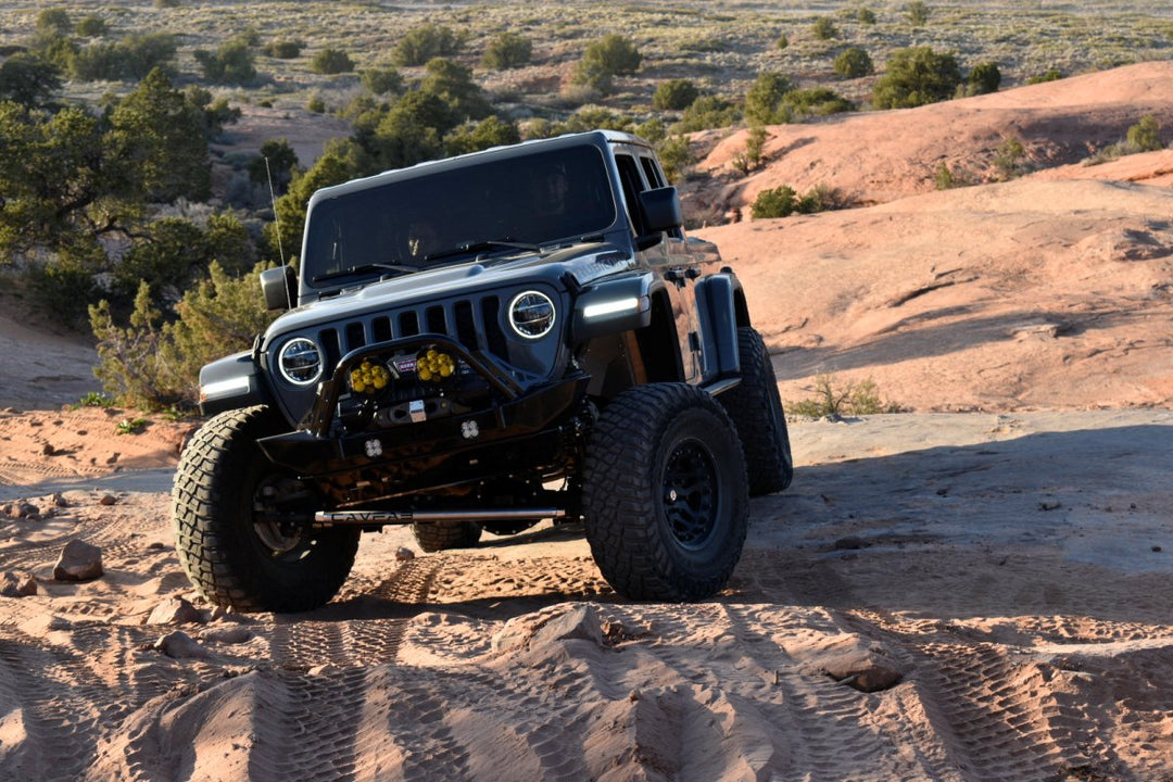Black Jeep Wrangler rock crawling in desert terrain, showcasing off-road capability in Ford Bronco Sport vs Jeep Wrangler comparison.