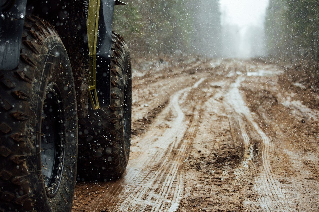 Closeup of wheel, mud, and rain as part of a comparison of the Ford Bronco vs Jeep Wrangler.