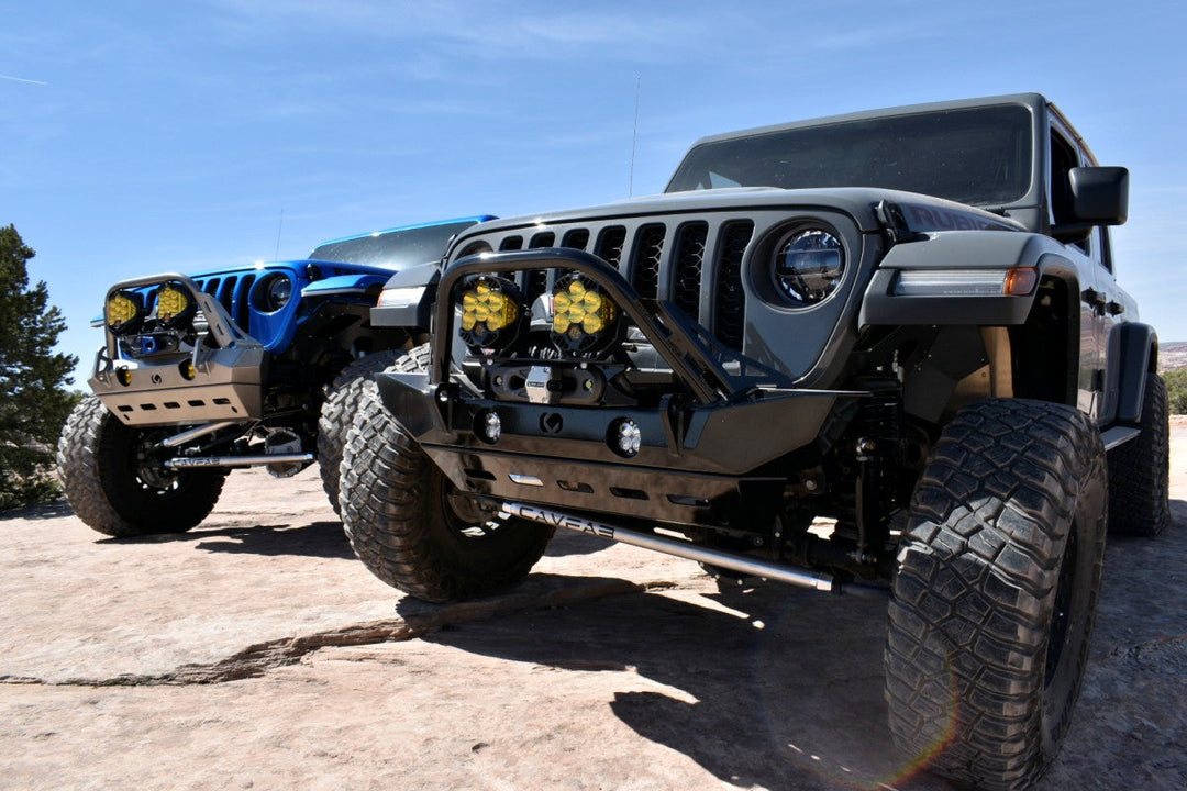 Two heavily modified Jeep Wranglers parked on slickrock terrain, illustrating key differences in the Jeep Wrangler vs Rubicon off-road comparison.