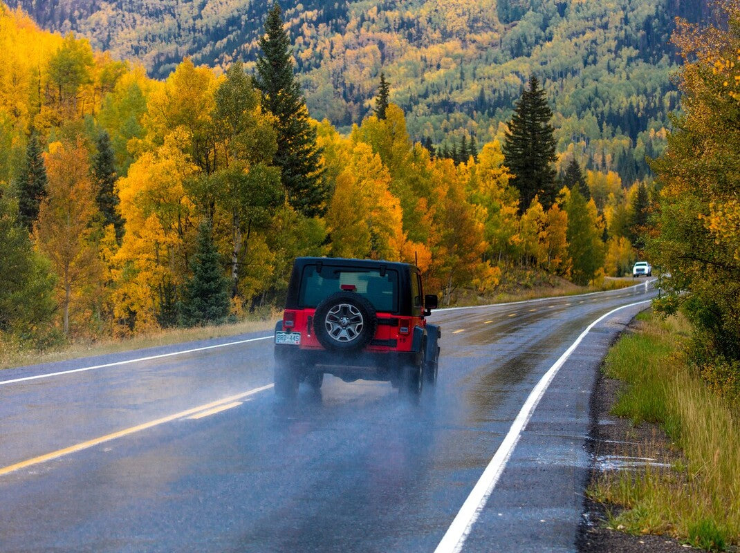 red Jeep driving down the road to show what is the best Jeep