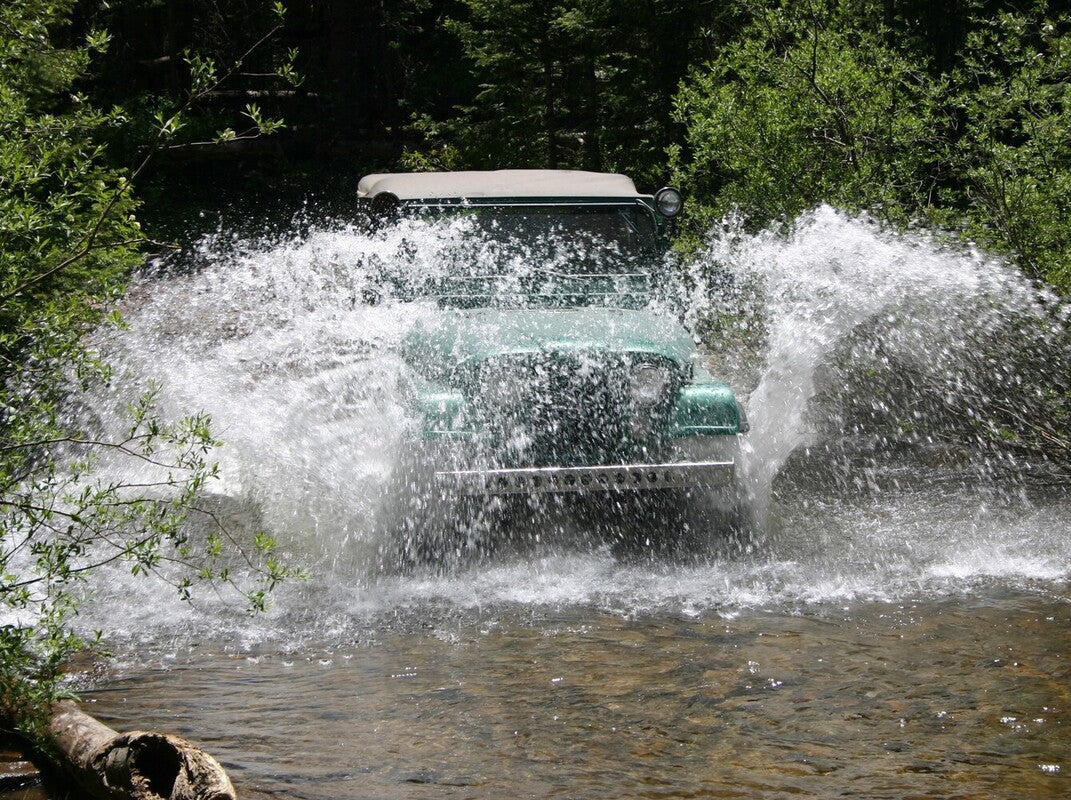 vintage Jeep going through water to showcase Jeep CJ5 vs CJ7