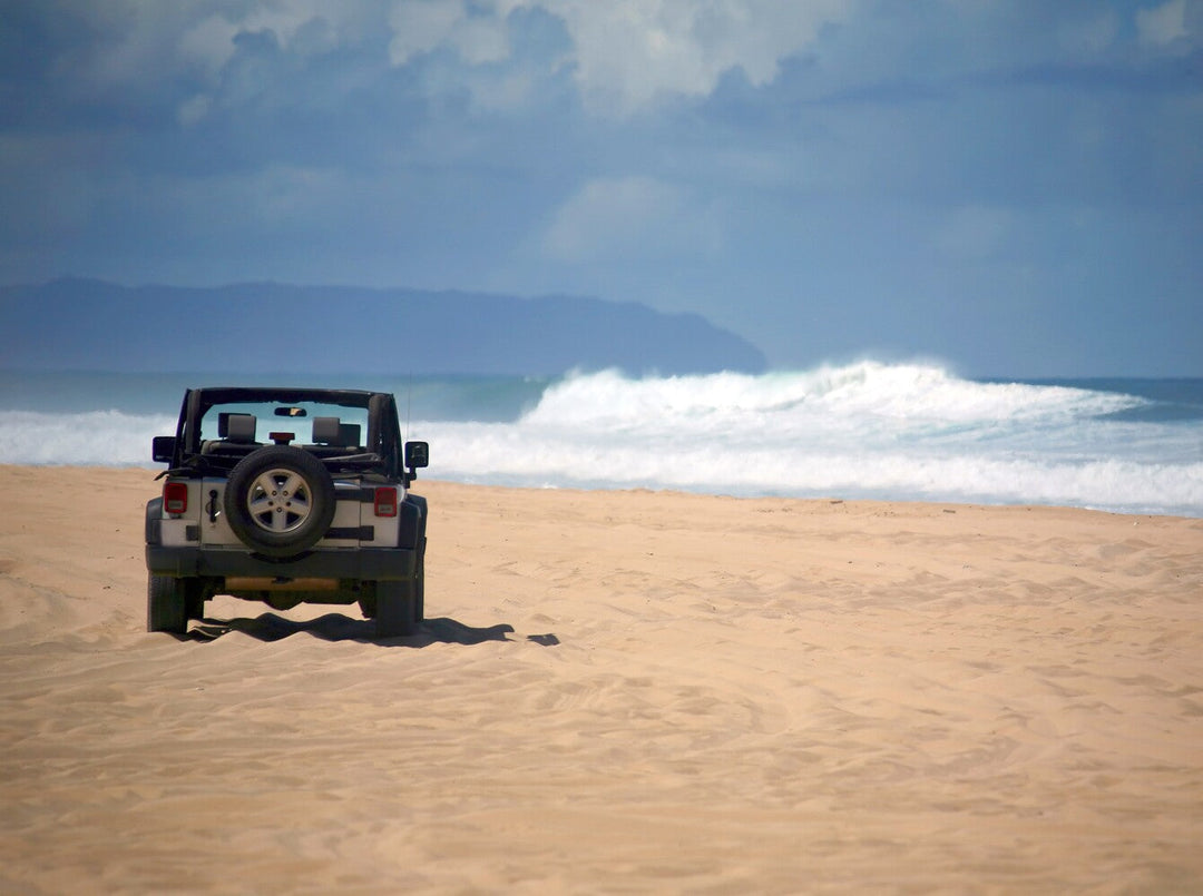 white Jeep on a beach to showcase Jeep vs Toyota reliability